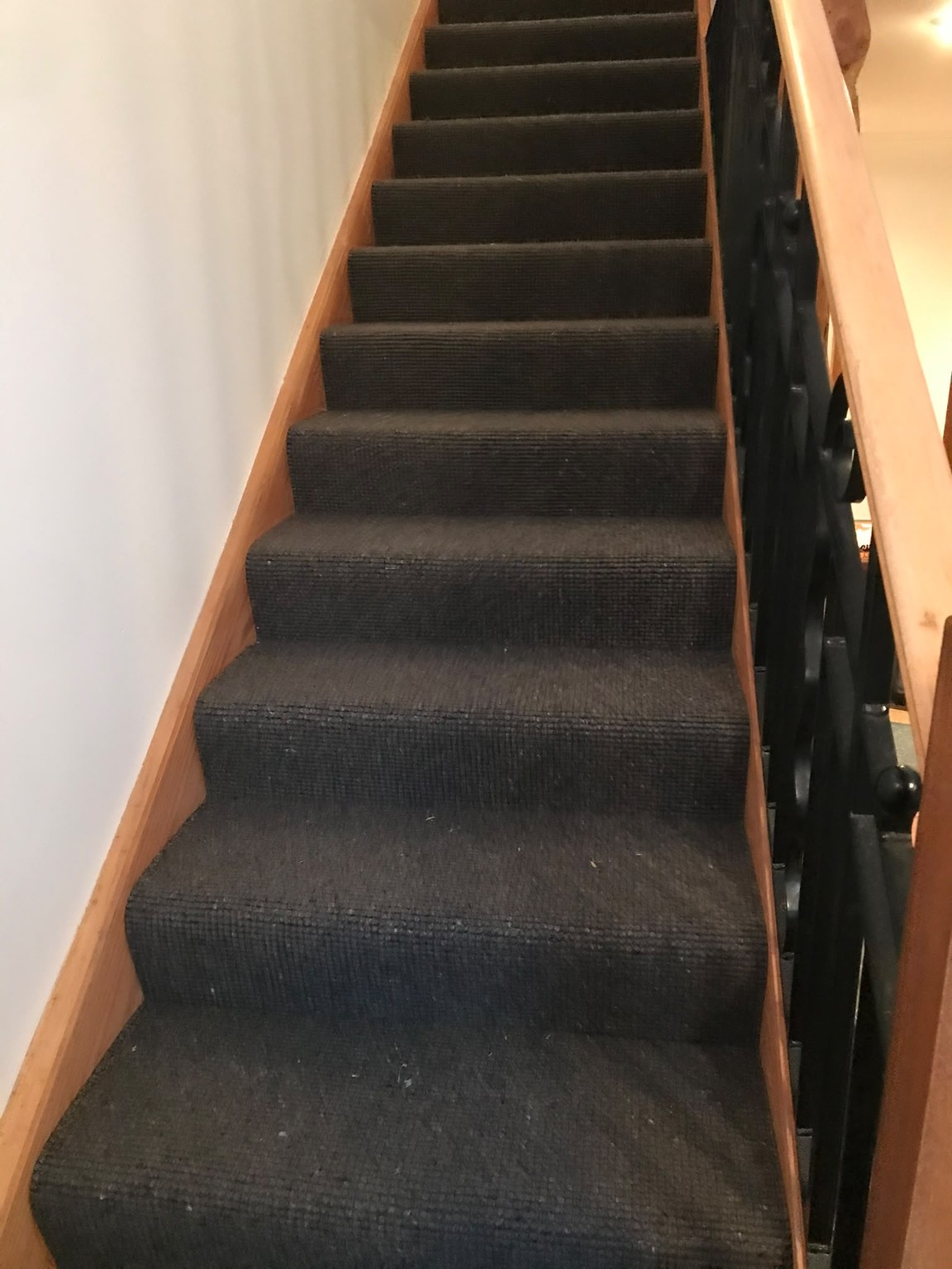 Dark carpet fitted neatly to a straight staircase