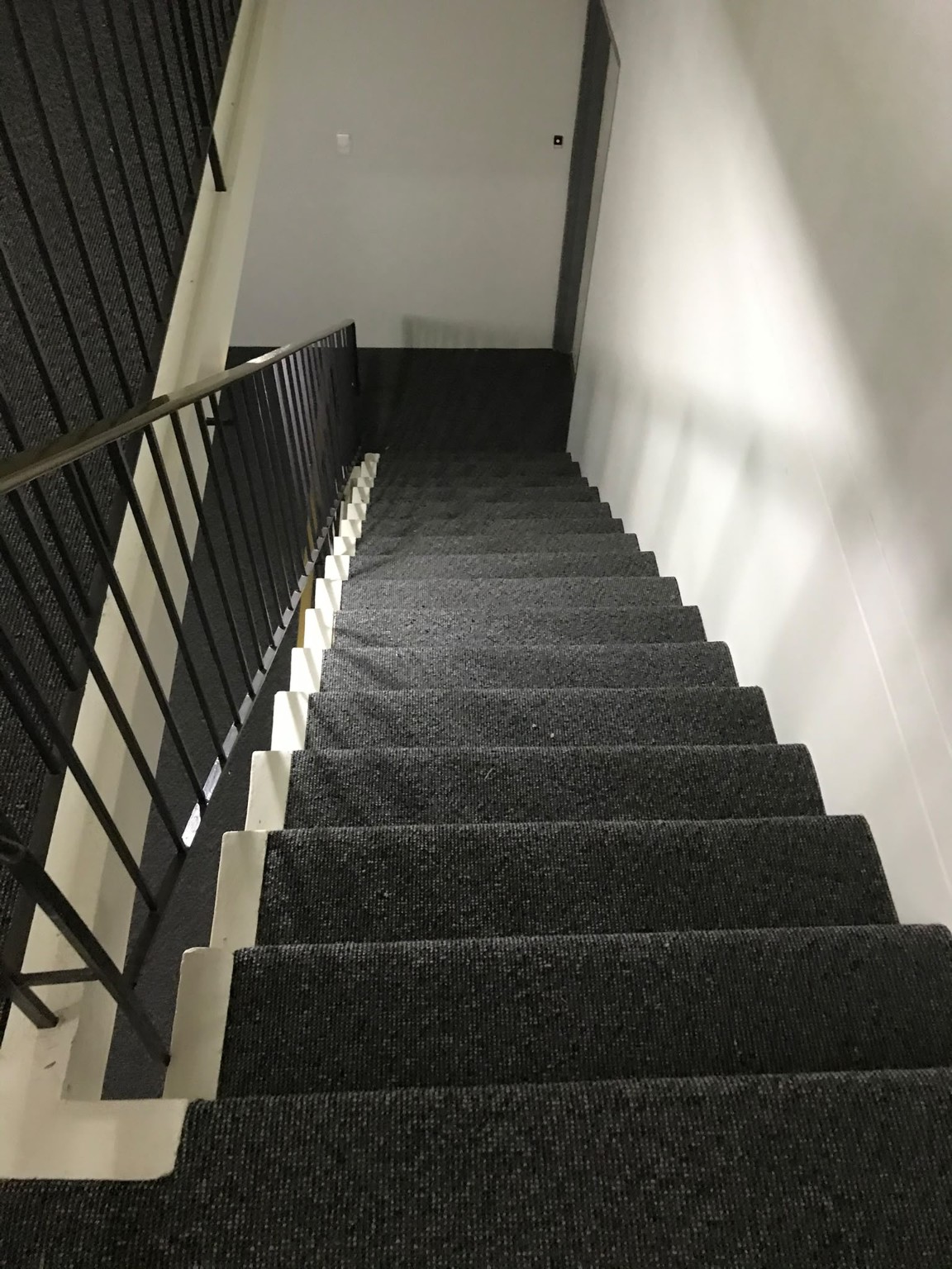 Dark commercial carpet fitted to a multi-level staircase